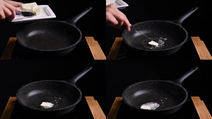一个人把黄油放在煎锅里。黄油在热煎锅中融化并起泡。高质量4k镜头