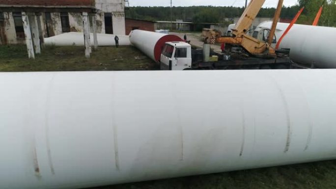 巨大的白色圆柱形支架位于建筑工地上。
