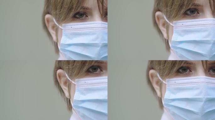 冠状病毒传播预防概念。特写年轻女性医生在灰色背景的医疗面罩，复制空间