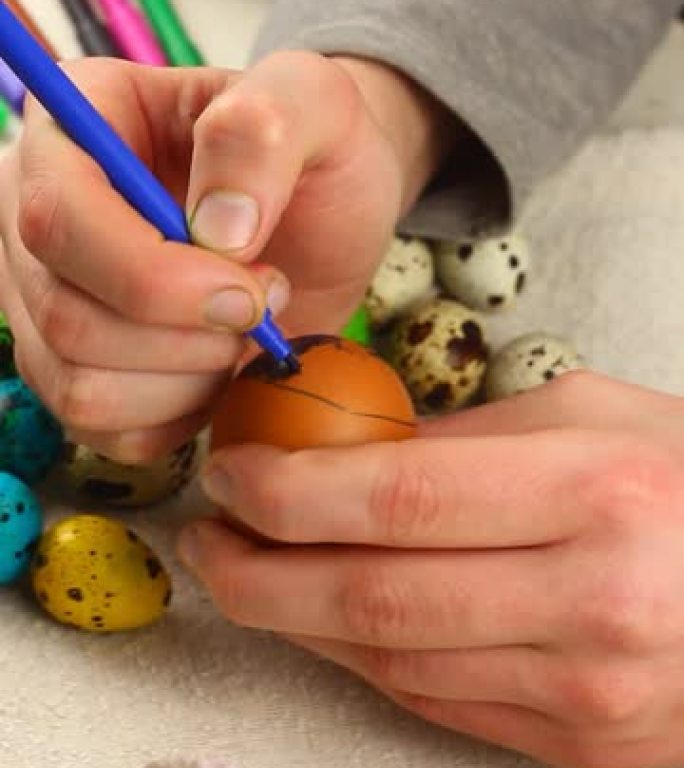 一个白人种族的孩子用毡尖笔特写画复活节彩蛋。复活节概念