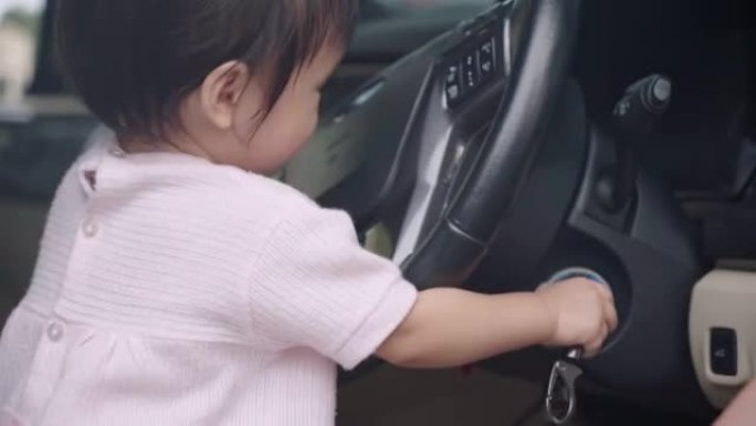 亚洲小女孩玩得开心玩汽车方向盘，汽车钥匙，假装开车，坐在驾驶员前排座位上，孩子好奇心和学习，快乐快乐