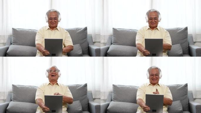 快乐的老年男性使用笔记本电脑收听在线流媒体数字技术wifi互联网连接享受音乐歌曲，老年人退休在家的生