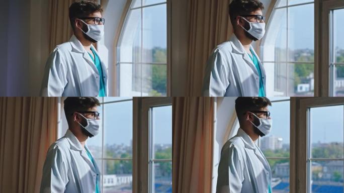 在一家现代医院里，戴着防护口罩的年轻医生稍事休息，他透过全景窗户看了一眼，并有一张思考的脸。在阿里·