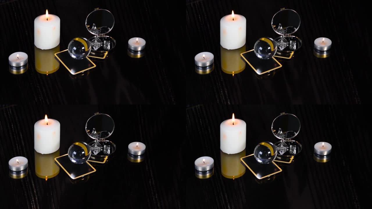 神奇的会议与塔罗牌，白色蜡烛，戒指和镜子在黑色背景。