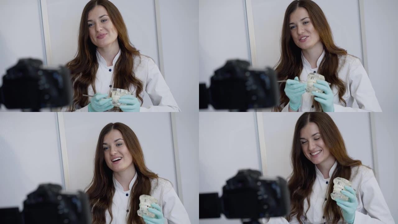 快乐的女牙医记录课在视频摄像机前使用下巴布局