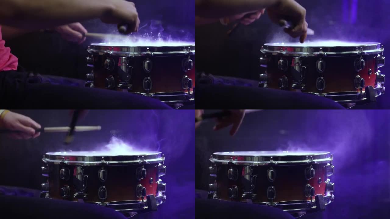 鼓手用小鼓上的棍棒演奏，灰尘收起。
