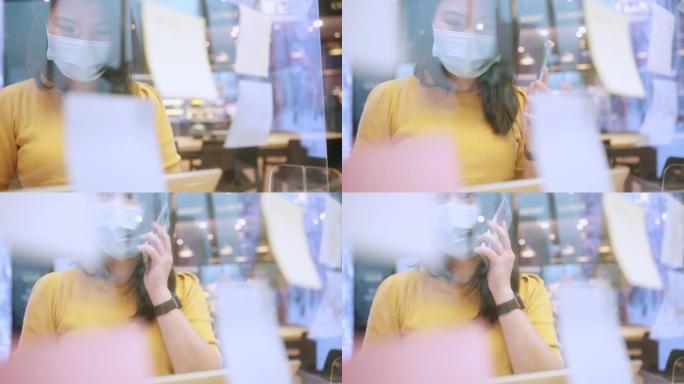 有吸引力的自由职业者亚洲女性创意人士穿着休闲黄布和面罩保护手点并写下办公空间新的生活方式