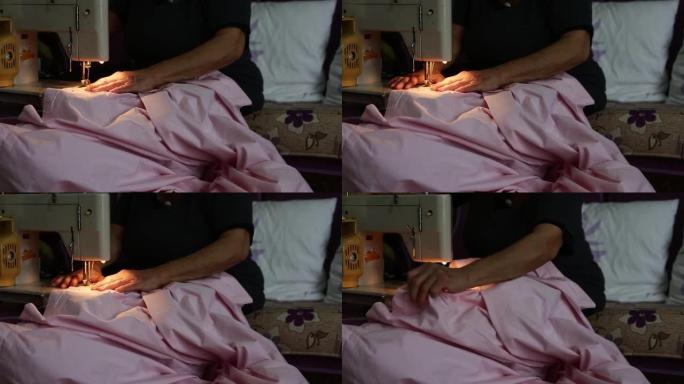 一个女人在缝纫机上的被套上做扣眼