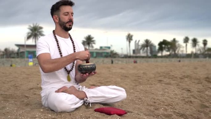 留着胡须的人练习瑜伽，冥想并在黎明时在海滩上打藏族歌仔戏