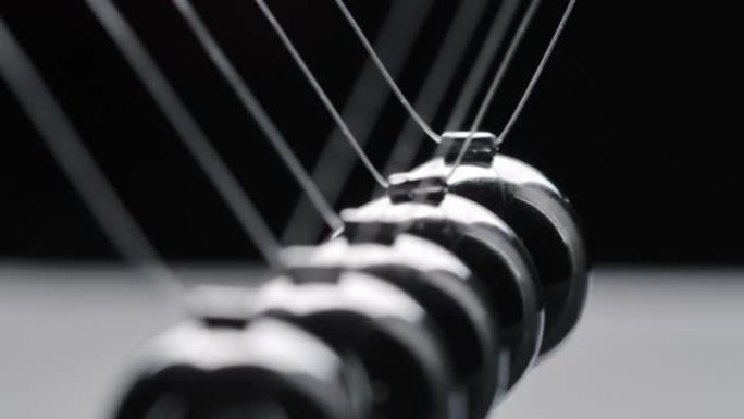 黑色背景上运动的钢牛顿球的视频