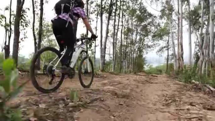 女人在山顶森林小径上骑自行车