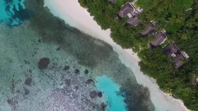 马尔代夫维尔京岛的鸟瞰图和异国情调的白色沙滩上的度假胜地，带有水上别墅平房。蓝色泻湖和棕榈树。概念: