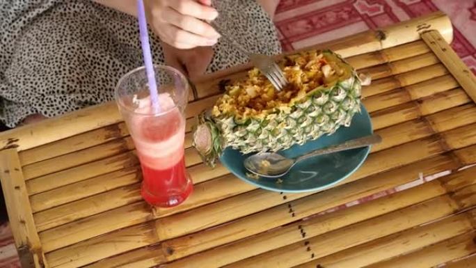 女人吃菠萝炒饭，在泰国很受欢迎