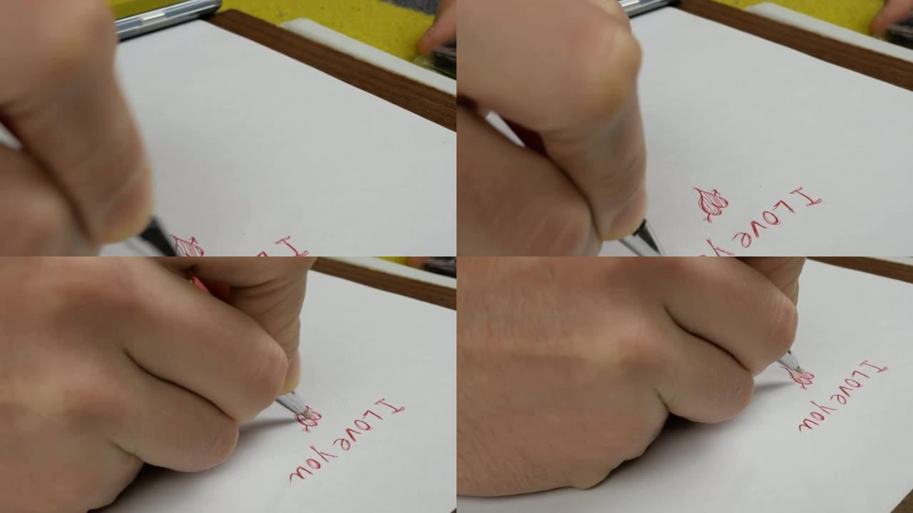 一个年轻人为他的女朋友画了一张情人卡。一个年轻人的手的特写镜头他用红笔在纸上写下我爱你的话