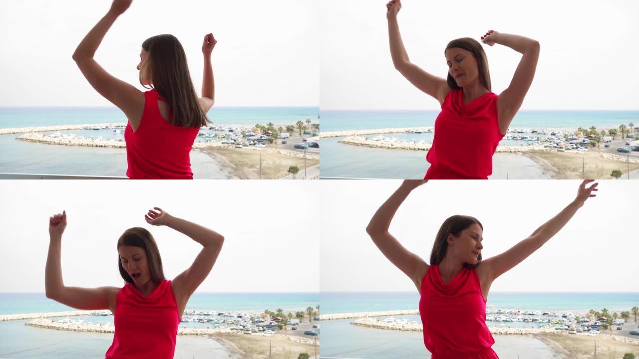 女人在海景露台上快乐地跳跃。傻女举起手臂慢动作跳舞