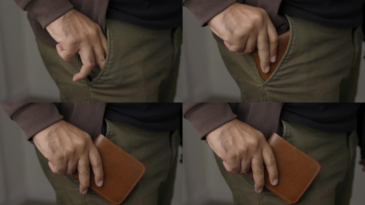 关闭男性的手从他的牛仔裤口袋里拿出钱包。展示钱包。金融业务概念。