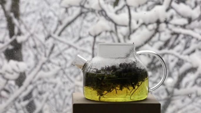 在冬季窗外降雪的背景下注入了热疗芳香凉茶