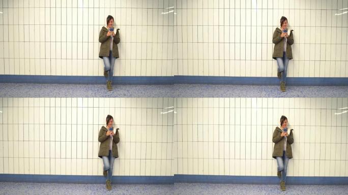 在汉堡地铁站使用电话的女人