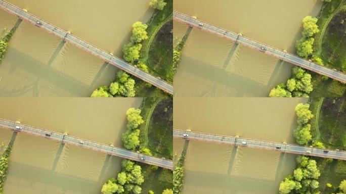 绿色农村地区泥泞宽河上的一座窄桥的鸟瞰图。
