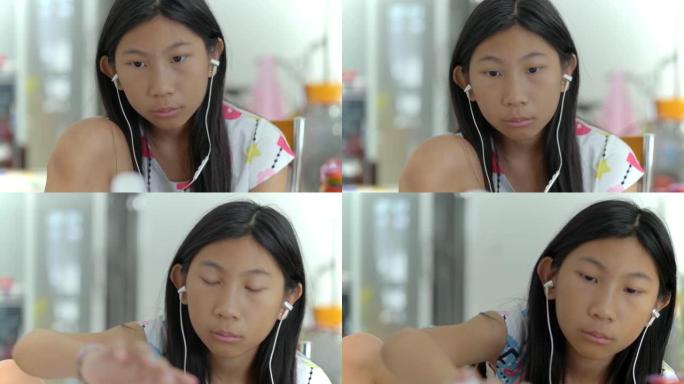 快乐的亚洲女孩使用耳塞和智能手机观看病毒视频，同时在家放松，生活方式概念。