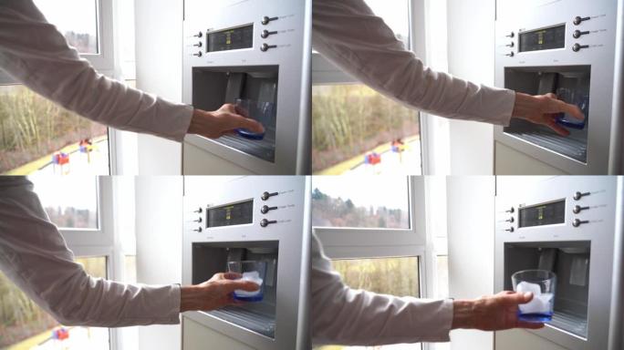 冰箱门中的制冰机将玻璃装满冰