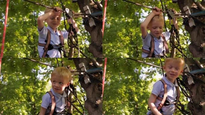 夏天在绳索公园里一个勇敢的小男孩的肖像，他拿着卡宾枪。