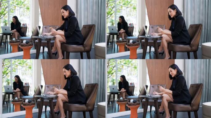 亚洲商务女性在明亮的休息区使用笔记本电脑。
