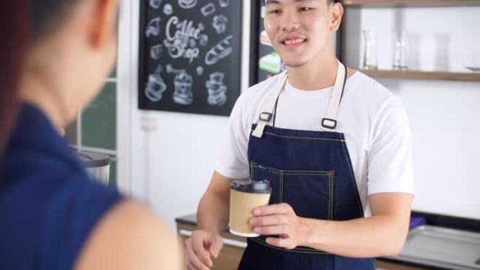 微笑的咖啡师在柜台上向顾客提供热咖啡