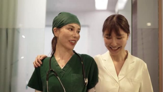 亚洲女医生和护士在医院走出手术室交谈。