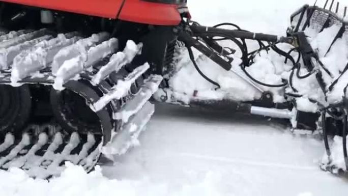 宽阔的雪猫在雪地上骑行的特写作品，并在雪山的背景下将其耙动。为滑雪季节和积雪准备雪坡的概念