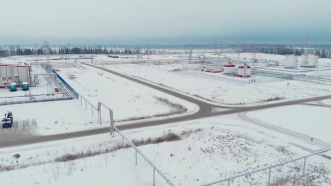 电影空中无人机镜头。在油气田用油和水飞越储层。冬季的西伯利亚针叶林。直升机飞行