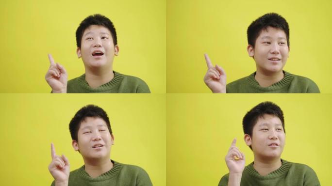 快乐的亚洲男孩有想法，并以黄色背景，生活方式为概念。