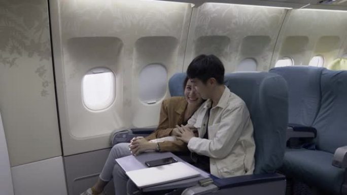 亚洲情侣游客乘飞机旅行。
