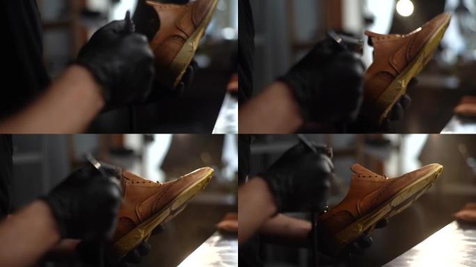 鞋匠在黑色手套中特写镜头，用防水喷雾喷涂旧棕色皮鞋。