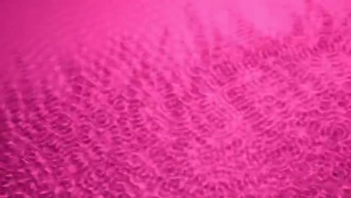 粉色水面上的声波振动特写。抽象水背景
