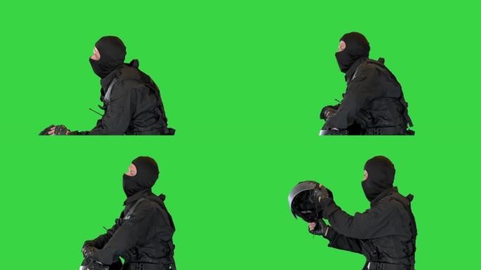 防暴警察戴着头盔坐在绿色屏幕上休息