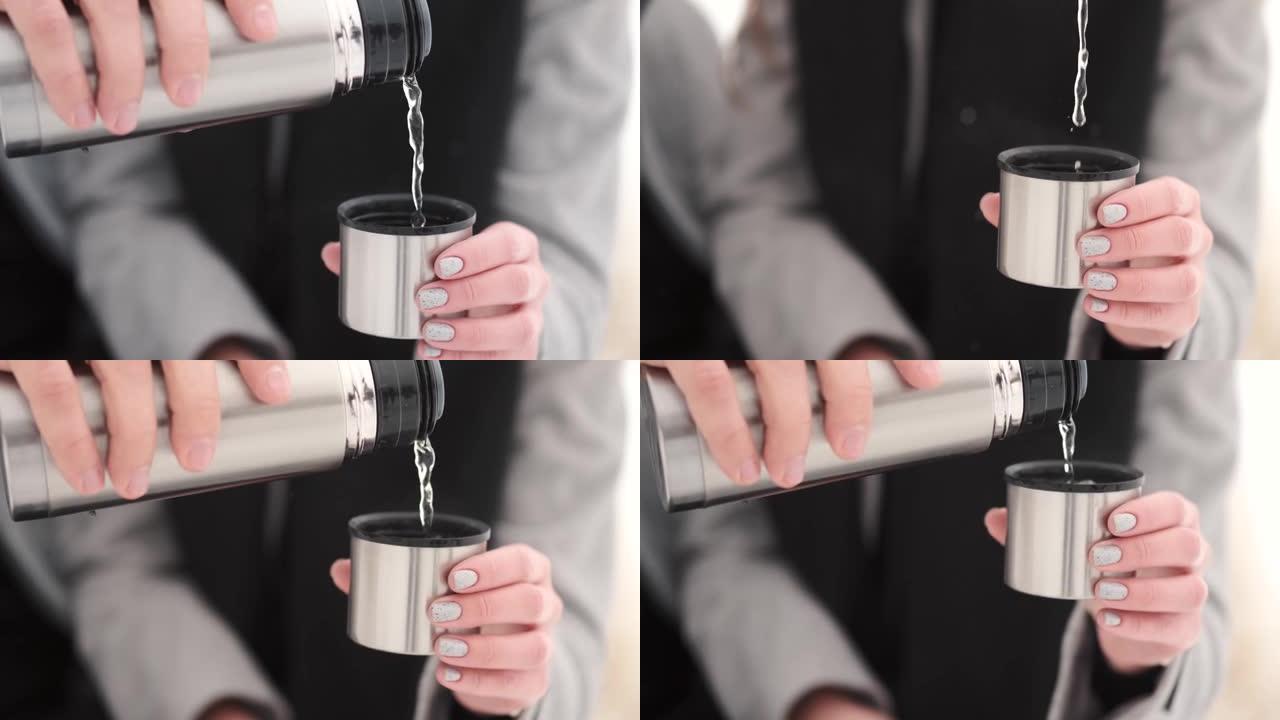 男人用戒指从杯子里的热水瓶里倒茶