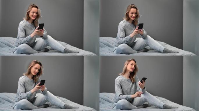 国内睡衣上网的微笑女性在床上使用智能手机。4k龙红相机