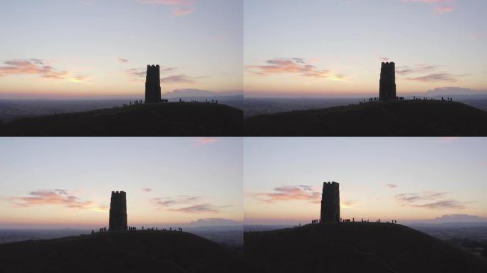 晚上在格拉斯顿伯里 (Glastonbury Tor) 上空飞行，游客在英国萨默塞特 (Somers