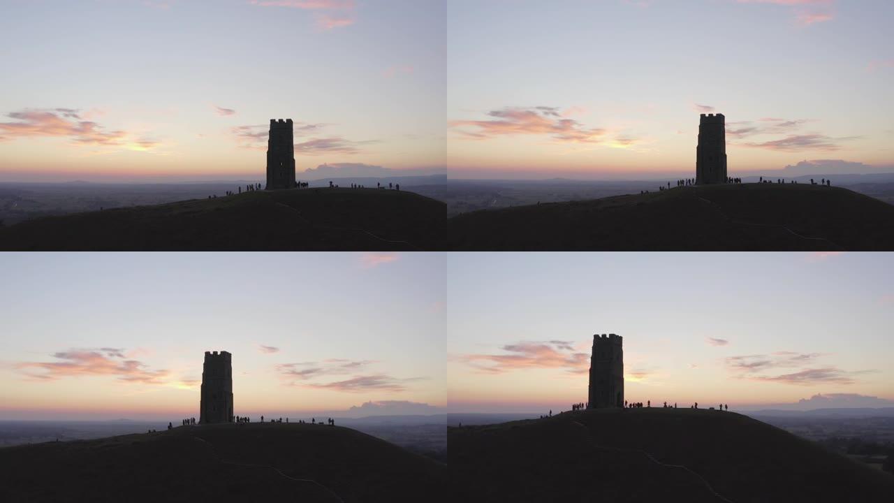 晚上在格拉斯顿伯里 (Glastonbury Tor) 上空飞行，游客在英国萨默塞特 (Somers