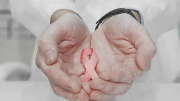 乳腺癌意识医生手中的粉红丝带