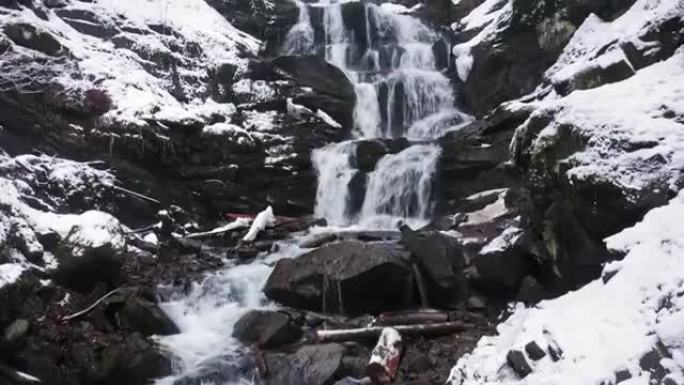 山区的冬季瀑布。水冲破冰雪