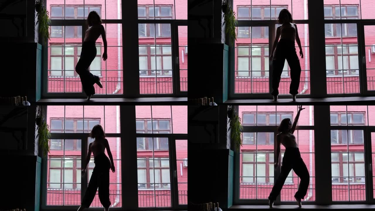 一个大窗户背景上跳舞的女人的剪影