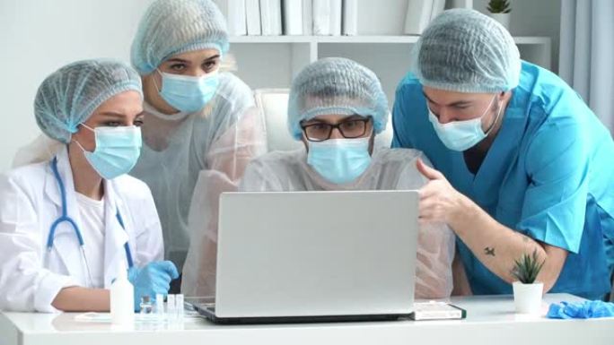 医疗手套，白大褂和防护口罩的医生团队的特写镜头讨论患者在诊所的笔记本电脑的诊断。冠状病毒，新型冠状病