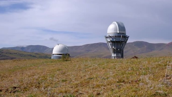 白天在山脉之间的绿色山谷上的天文台望远镜，可用于任何目的。