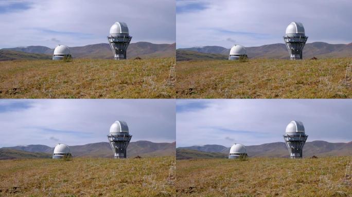 白天在山脉之间的绿色山谷上的天文台望远镜，可用于任何目的。