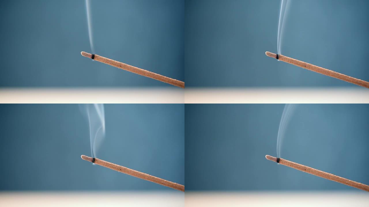 燃烧香气棒，白烟，蓝色背景特写，高清视频