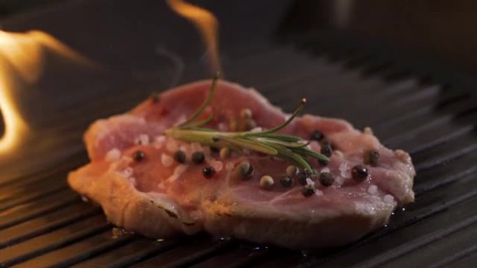 带有火焰的多汁煮熟的肉片的特写视图。烧烤烧菜的原始食谱