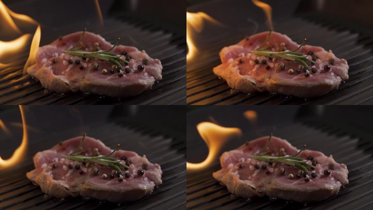 带有火焰的多汁煮熟的肉片的特写视图。烧烤烧菜的原始食谱