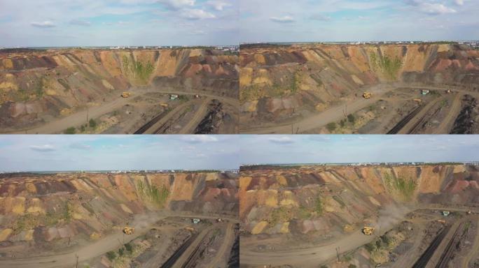 在尘土飞扬的道路上行驶的大型矿用自卸车鸟瞰图